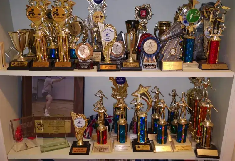 Shelf of badminton trophies and medals